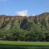 Kapi'olani Park, with its broad green lawn, rises to meet Diamond Head.