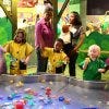 Children in raincoats enjoying the water table exhibit at Imagine It! The Children's Museum of Atlanta.