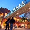A shopping couple walks under the neon entrance sign at the Dolphin Mall in Miami, Florida.