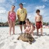Guests interact with a tortoise in Orlando's Aquatica waterpark