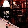 Dimly lit room with pool table and chess set at the Rose Bar