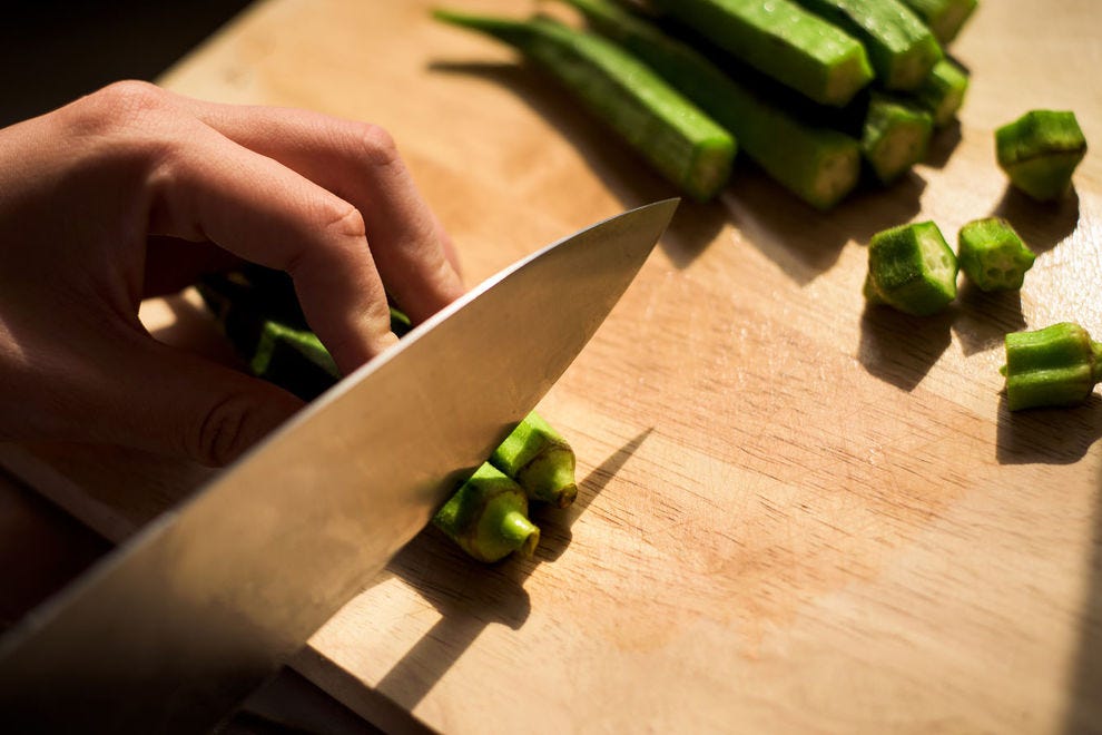 Slicing the stems off okra